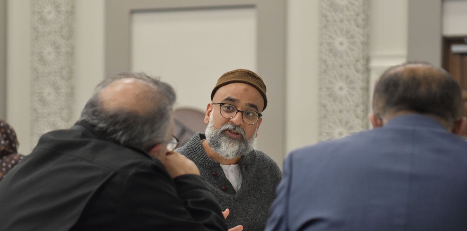 Three delegates in conversation during a roundtable.