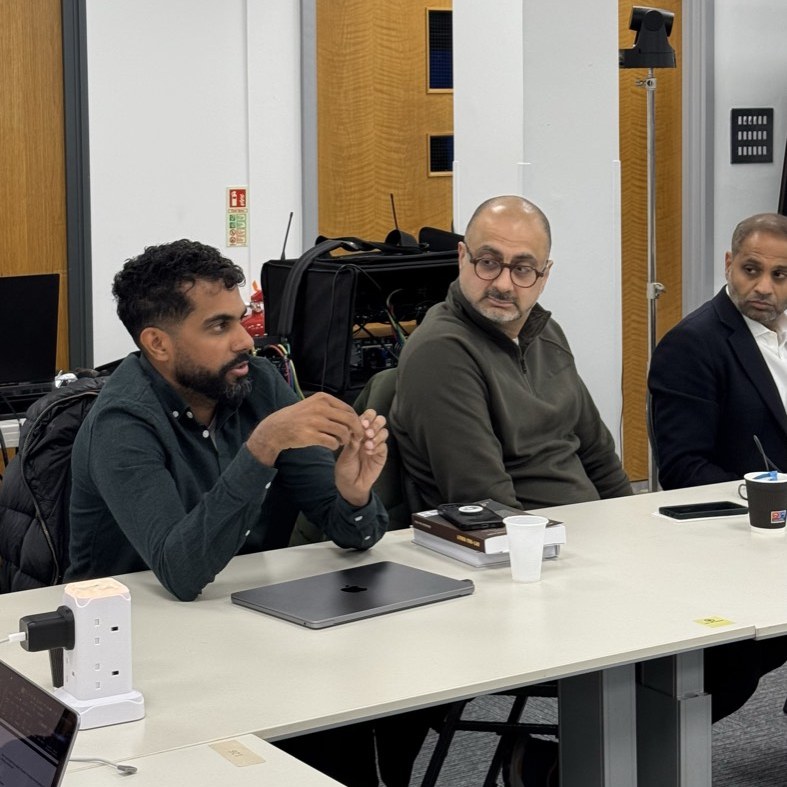 Three participants at the seminar table, the one on the left speaking.